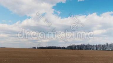 早春时节沿着犁过的田地<strong>快速行驶</strong>。可见的农田和蓝天白云。POV窗口